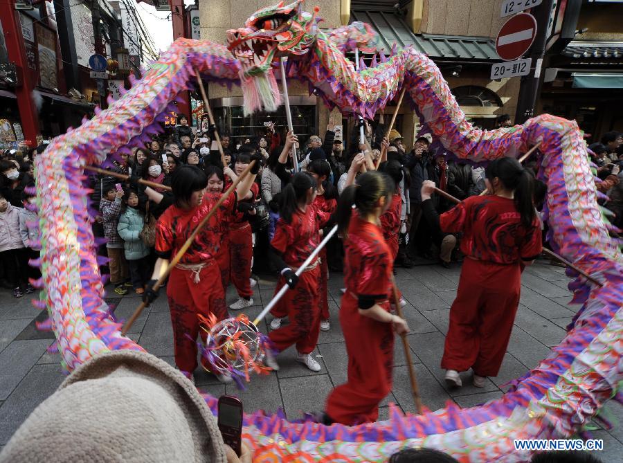 Performers in traditional Chinese costumes play a dragon dance during a parade celebrating the Lunar New Year in the Chinatown in Yokohama, Japan, Feb. 17, 2013.