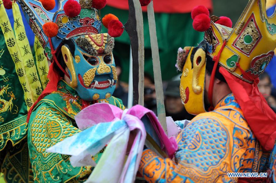 Performers perform Nuo dance, a kind of exorcising dance, during the 14th Folk Culture Festival in Liyang City, east China's Jiangsu Province, Feb. 17, 2013.