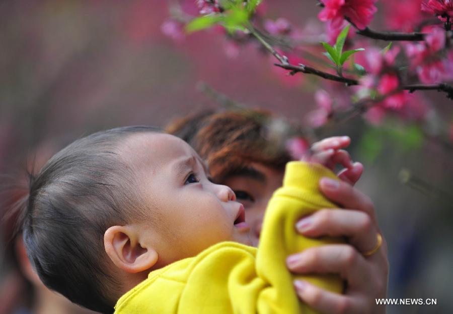 A child plays with petals at Baiyun mountain in Guangzhou, capital of south China's Guangdong Province, Feb. 18, 2013. 