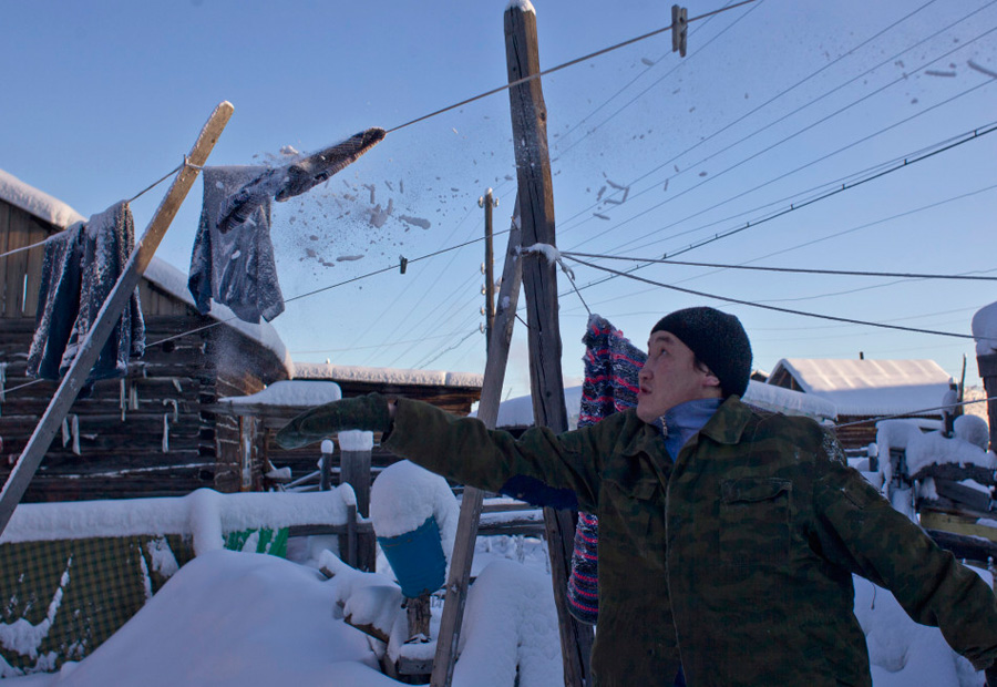 25岁的Igor Vinokurov敲掉晾衣绳上的积雪和冰柱。村民们世代生活在冰天雪地中，对零下四五十度的温度早已习以为常。 