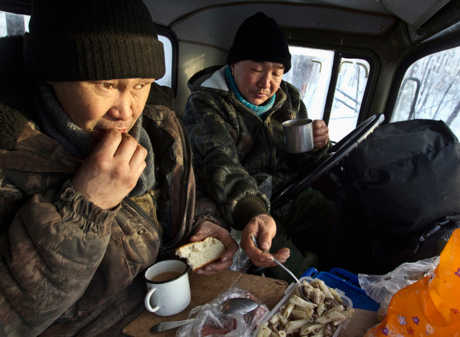 工作间隙，Alexey Egorov和Semion Vinokurov在卡车车厢内进食。由于这里不长庄稼，村民日常主要食用驯鹿肉和马肉。奇怪的是，当地人并没有营养不良，医生说，秘诀在于当地人摄入动物奶，奶中含有多种微量元素。 