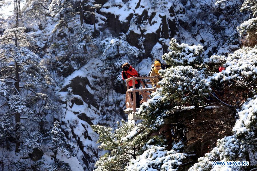 A visitor takes photos of the snow scene at the Huangshan Mountain scenic area in east China's Anhui Province, Feb. 20, 2013.