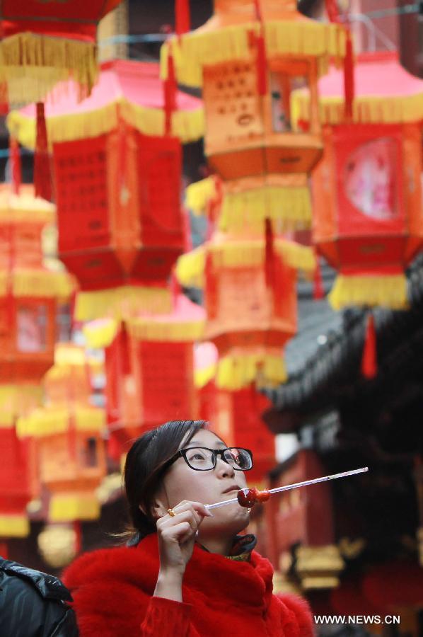 A girl guesses lantern riddles at the Yuyuan Garden in Shanghai, east China, Feb. 20, 2013. 