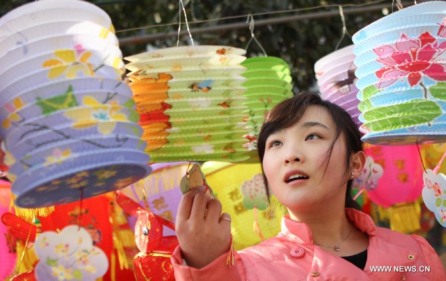 A girl chooses lanterns at a market in Huaibei, east China's Anhui Province, Feb. 20, 2013. 