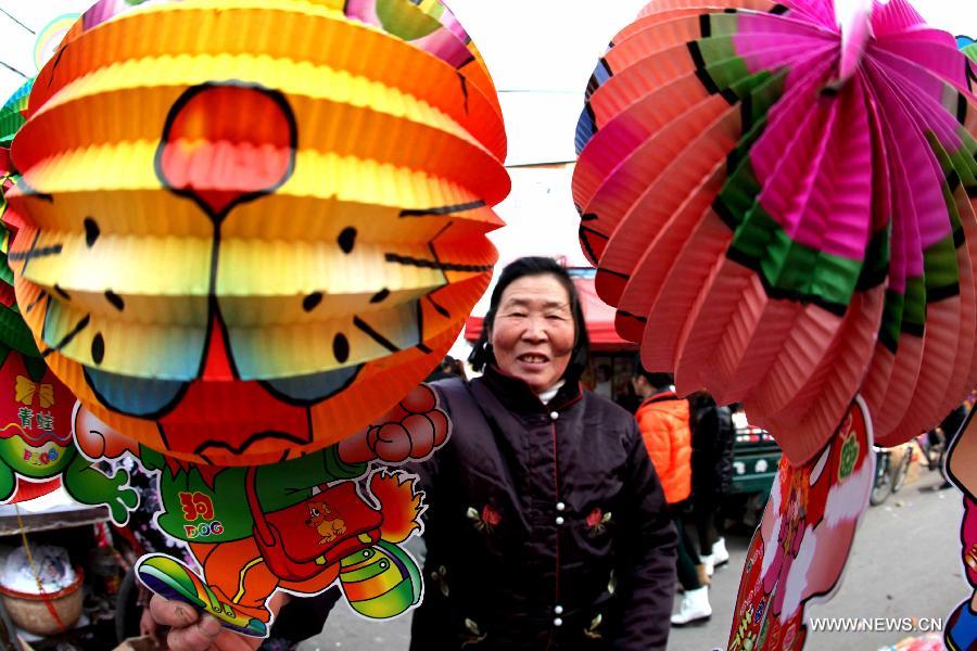 A woman looks at lanterns made with environment-friendly paper at a market in Bozhou, east China's Anhui Province, Feb. 20, 2013.