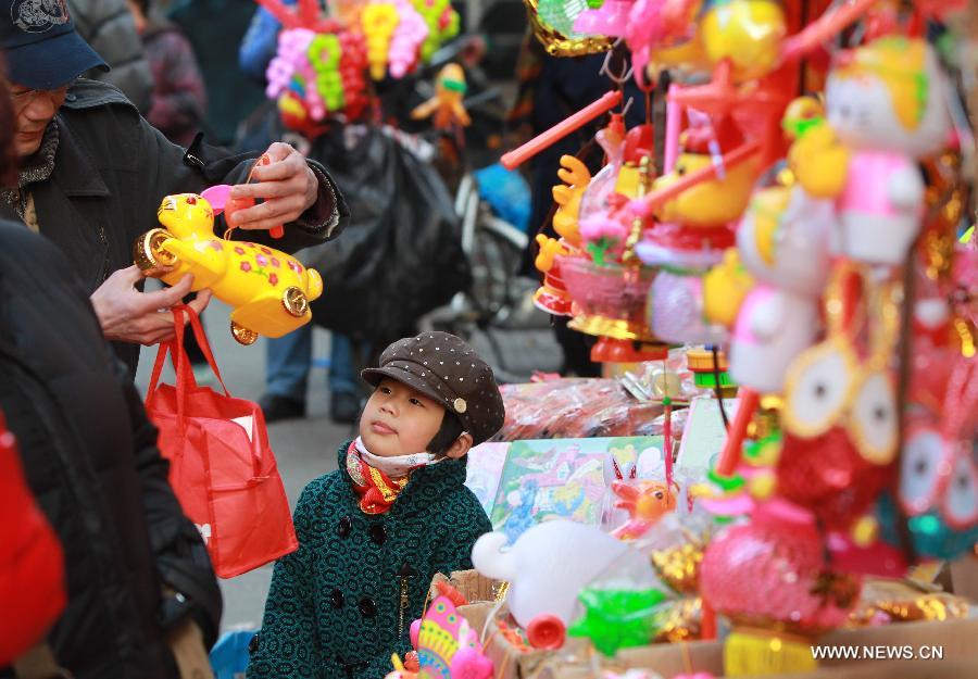 A father chooses a lantern for his child at a market in Shanghai, east China, Feb. 20, 2013. 