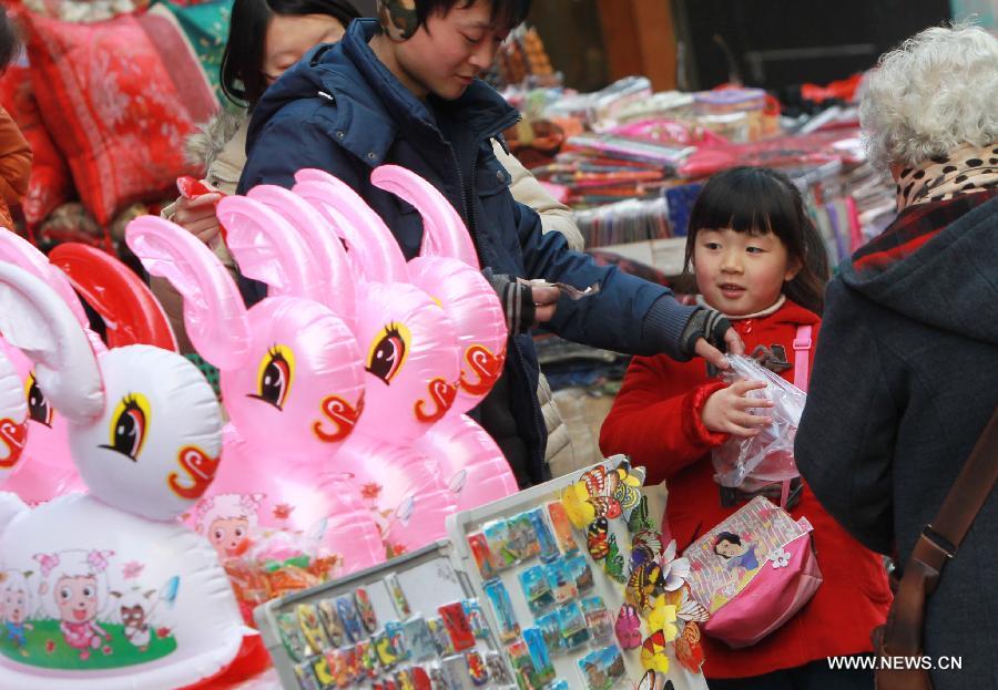 A girl buys a lantern at a market in Shanghai, east China, Feb. 20, 2013.