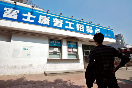 A jobseeker outside the closed job center at a Foxconn factory in south China's Shenzhen Thursday. The Chinese words on the sign say: Recruiting Center for Common Employees of Foxconn. Foxconn Technology Group, Apple's manufacturing partner, has frozen hiring at a Shenzhen plant that makes gadgets including the iPhone 5. [File Photo]