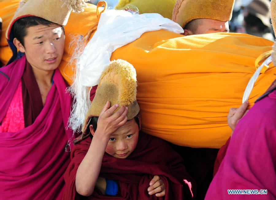 Lamas carry a gigantic Buddha tangka to a hillside for an anual display ritual in Labrang Monastery in Xiahe, northwest China's Gansu Province, Feb. 22, 2013.