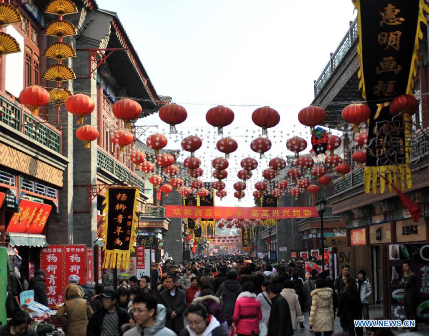 Visitors enjoy themselves at an ancient street in north China&apos;s Tianjin Municipality, Feb. 23, 2013. As the Lantern Festival falls on the next day, various lanterns were set up at the ancient street, which offers a place for local citizens in Tianjin to experience the culture of the festival. 