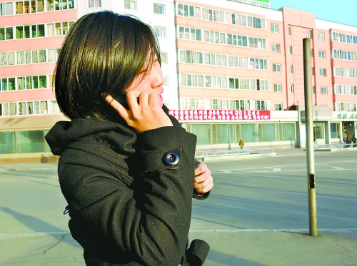 In this photo taken on Nov. 28, 2012, a girl uses her mobile phone on the street of Pyongyang. Foreigners who lives in the Democratic People's Republic of Korea (DPRK) will soon be allowed to get access to mobile Internet starting as of Feb. 25, 2013. [CFP]