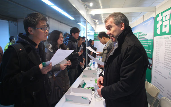 A job seeker speaks with a recruiter who represents a foreign-funded enterprise at a job fair organized by the Beijing Municipal Bureau of Human Resources and Social Security at the China International Exhibition Center in Beijing on Sunday.[Photo/ China Daily]