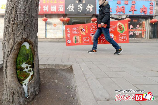 Student painter Wang Yue shows her talent by painting tree holes in Shijiazhuang, capital city of Hebei Province. [Photo/yzdsb.com.cn] 