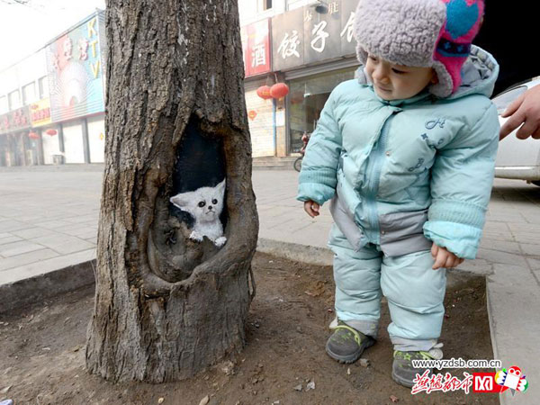 Student painter Wang Yue shows her talent by painting tree holes in Shijiazhuang, capital city of Hebei Province. [Photo/yzdsb.com.cn]