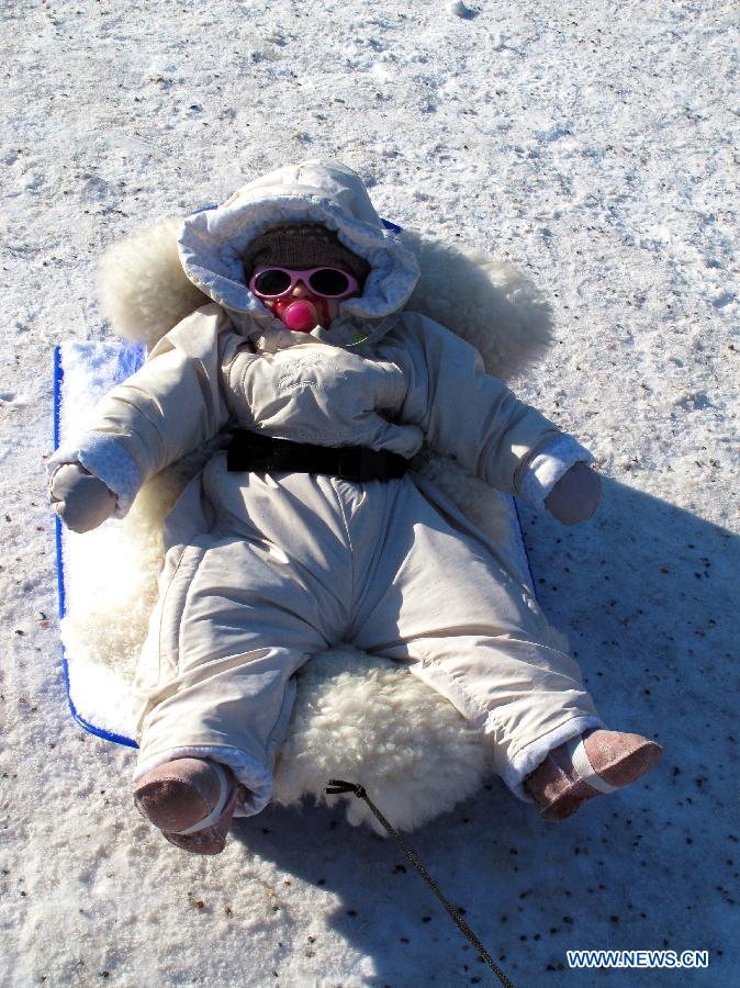 A child takes a nap on a plastic sleigh in Mustikkamaa, Helsinki, Finland, on Feb. 25, 2013. 