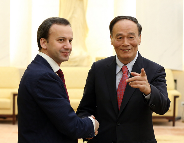 Vice-Premier Wang Qishan meets his Russian counterpart, Deputy Prime Minister Arkady Dvorkovich, at the Great Hall of the People in Beijing on Monday. They held talks on energy cooperation between the two countries. [Photo/China Daily]