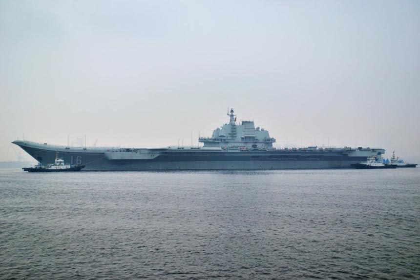 China's first aircraft carrier, the Liaoning, leaves the Dalian ship building company wharf on Tuesday for Qingdao, Feb. 26, 2013. The carrier anchored for the first time in a military port in Qingdao, eastern Shandong province Wednesday morning. It had conducted tests on its weapon system during the sail.