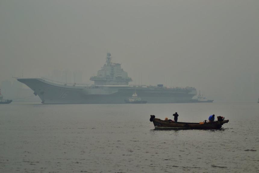 China's first aircraft carrier, the Liaoning, leaves the Dalian ship building company wharf on Tuesday for Qingdao, Feb. 26, 2013. The carrier anchored for the first time in a military port in Qingdao, eastern Shandong province Wednesday morning. It had conducted tests on its weapon system during the sail.
