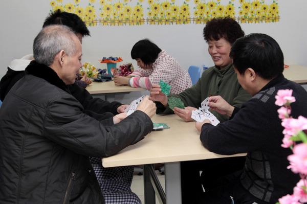 A doctor plays cards with patients at the Nanjing Brain Hospital. [Photo/China Daily] 