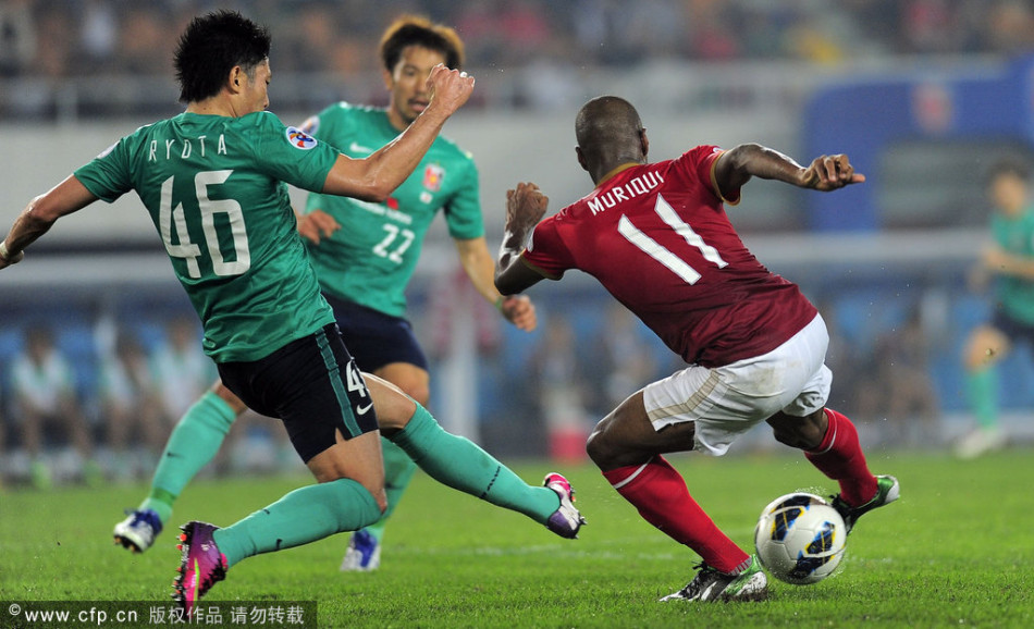 Muriqui of Guangzhou Evergrande tries to dribble past Ryota Moriwaki of Urawa Red Diamonds in a Group F match of AFC Champions League in Tianhe Stadium, Guangzhou, on Feb.26, 2013.
