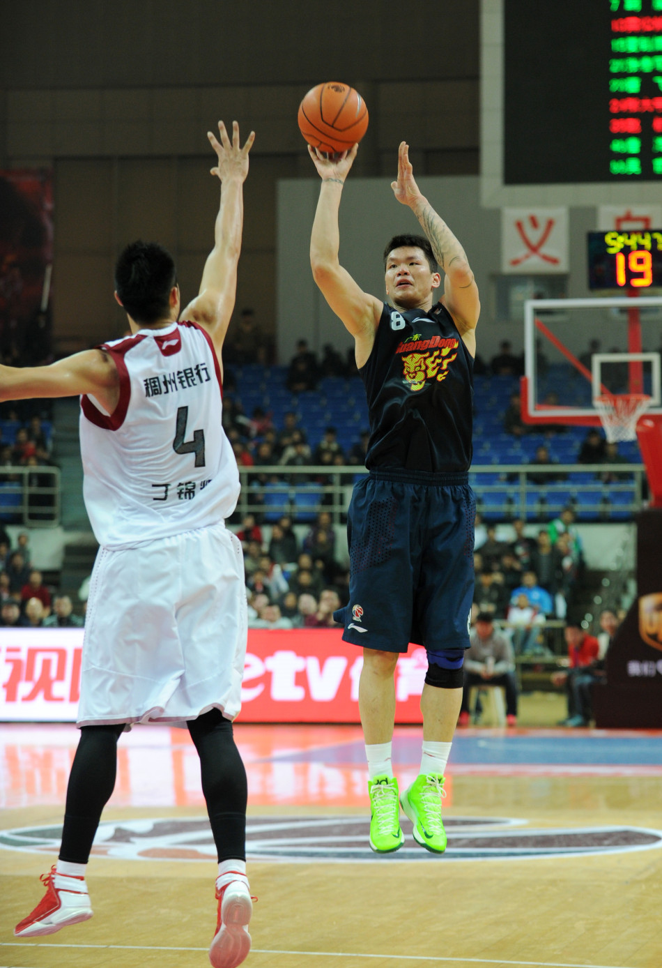 Guangdong Hongyuan's Zhu Fangyu shoots a 3 pointer in the face of Ding Jinhui of Zhejiang in the first round of CBA playoffs in Yiwu, Zhejiang, on Feb.27, 2013. 