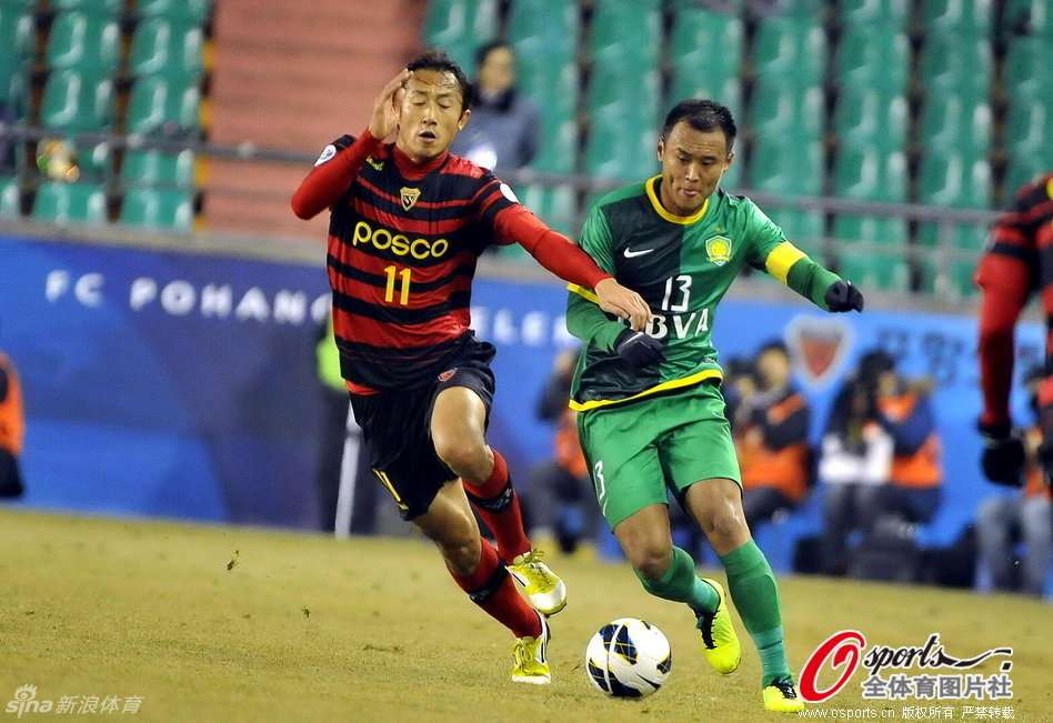 Xu Yunlong of Beijing Guoan and Seong-Ho Park of Pohang Steelers vie for the ball in a AFC Champions League match at The Steelyard, Pohang, on Feb.27, 2013. 