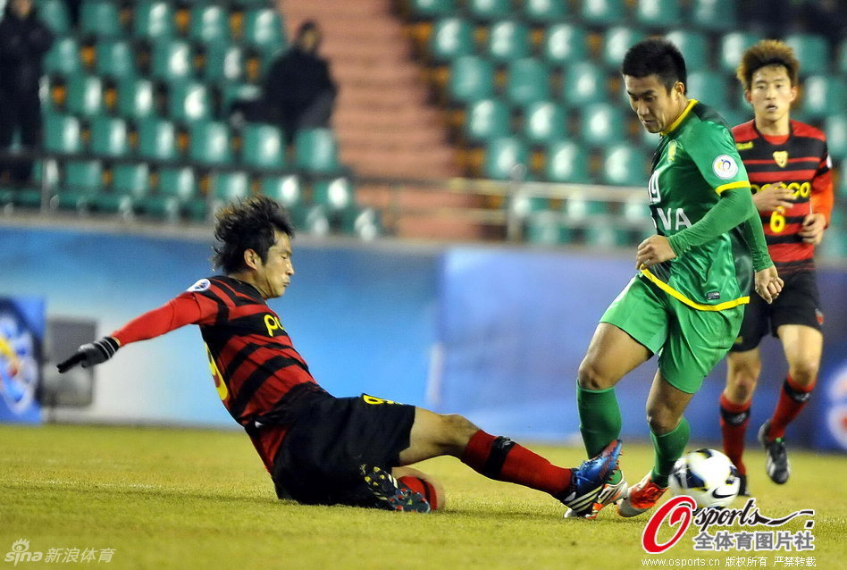Ji-Soo Hwang of Pohang Steelers tries to stop Wang Xiaolong of Beijing Guoan in a AFC Champions League match at The Steelyard, Pohang, on Feb.27, 2013. 