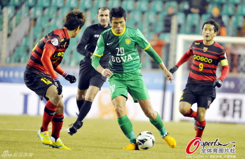 Shao Jiayi of Beijing Guoan tries to dribble past Pohang Steelers' defender in a AFC Champions League match at The Steelyard, Pohang, on Feb.27, 2013.