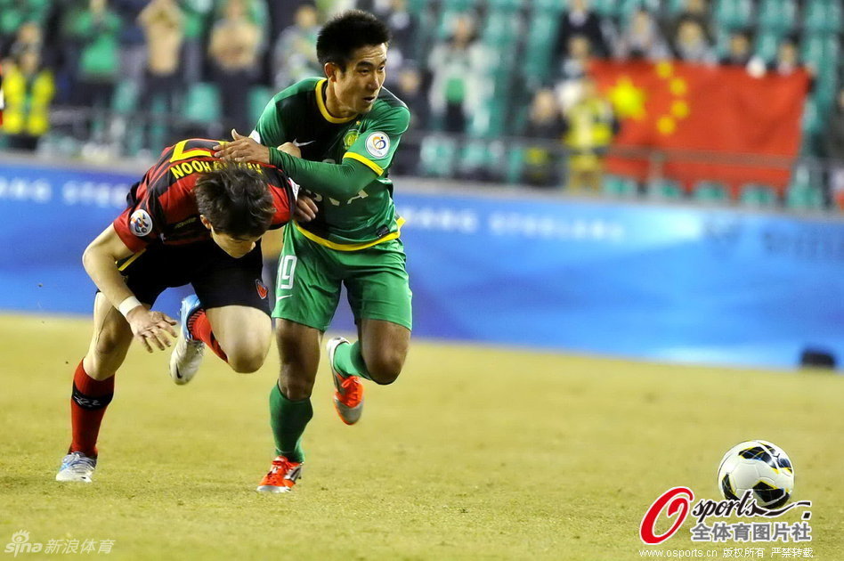 Wang Xiaoling of Beijing Guoan and Kwang-Hoon Shin of Pohang Steelers run for the ball in a AFC Champions League match at The Steelyard, Pohang, on Feb.27, 2013.