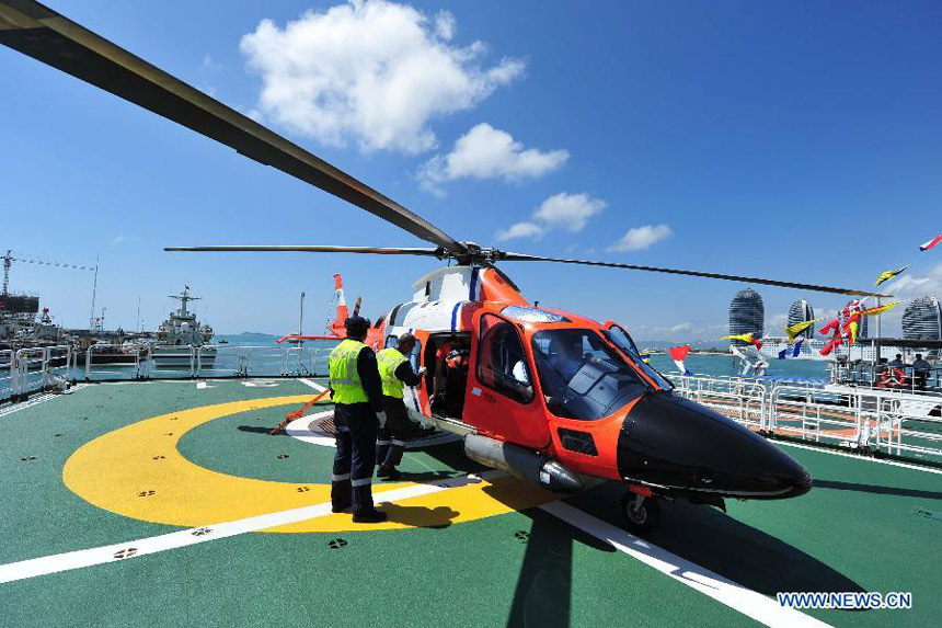 Staff members examine the helicopter carried by marine patrol ship &apos;Haixun 31&apos; before it sails out of the port of Sanya, south China&apos;s Hainan Province, Feb. 28, 2013. 