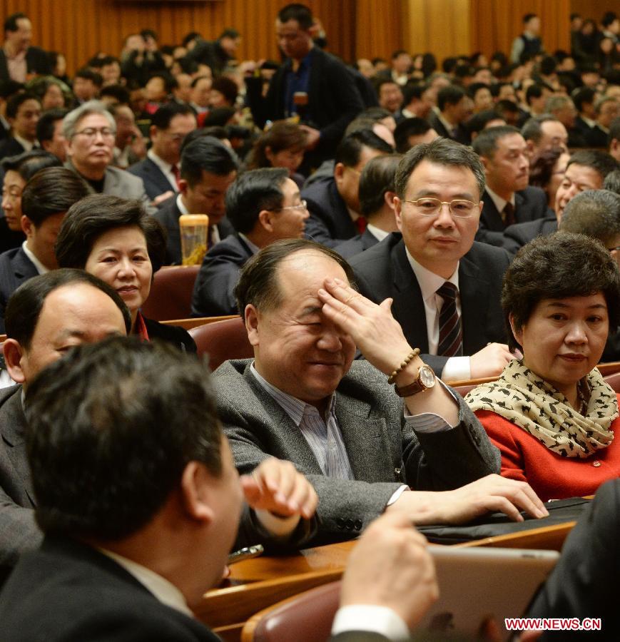 Mo Yan (C), a member of the 12th National Committee of the Chinese People's Political Consultative Conference (CPPCC), gestures while talking with another CPPCC member prior to the opening meeting of the first session of the 12th CPPCC National Committee at the Great Hall of the People in Beijing, capital of China, March 3, 2013.