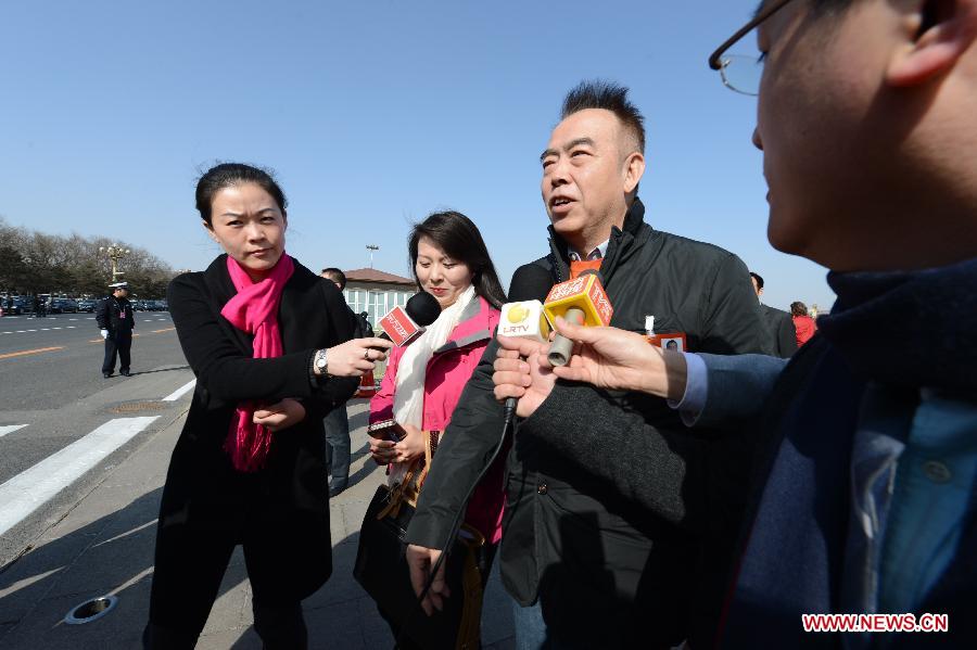 Chen Kaige (2nd R), a member of the 12th National Committee of the Chinese People's Political Consultative Conference (CPPCC), receives an interview outside the Great Hall of the People in Beijing, capital of China, March 3, 2013.