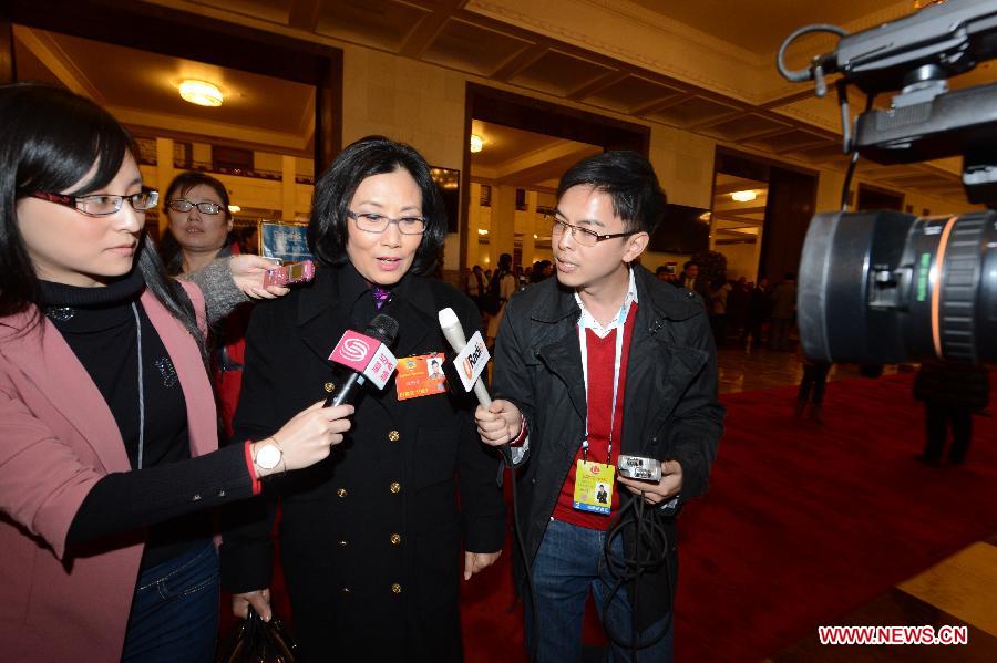 Liza Wang (2nd R), a member of the 12th National Committee of the Chinese People's Political Consultative Conference (CPPCC), receives an interview at the Great Hall of the People in Beijing, capital of China, March 3, 2013.