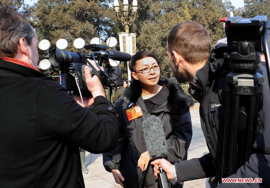 Song Dandan (C), a member of the 12th National Committee of the Chinese People's Political Consultative Conference (CPPCC), receives an interview by foreign journalists outside the Great Hall of the People in Beijing, capital of China, March 3, 2013. 