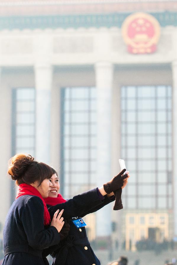 Staff members pose for a photo at the Tian'anmen Square in Beijing, capital of China, March 3, 2013. 