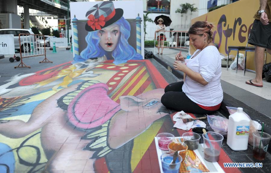 An artist draws on the ground in Bangkok, Thailand, March 2, 2013. 