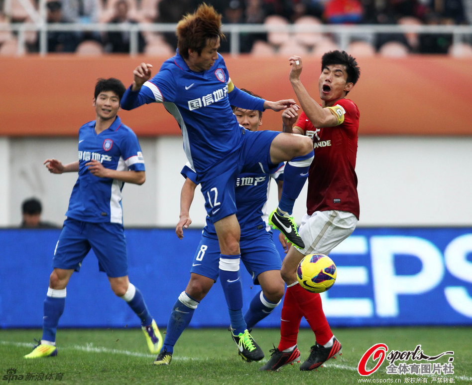 Ai Zhibo of Sainty and Zheng Zhi of Evergrande vie for the ball in the Chinese Super Cup in Guangzhou, Guangdong province, on March 3, 2013. 