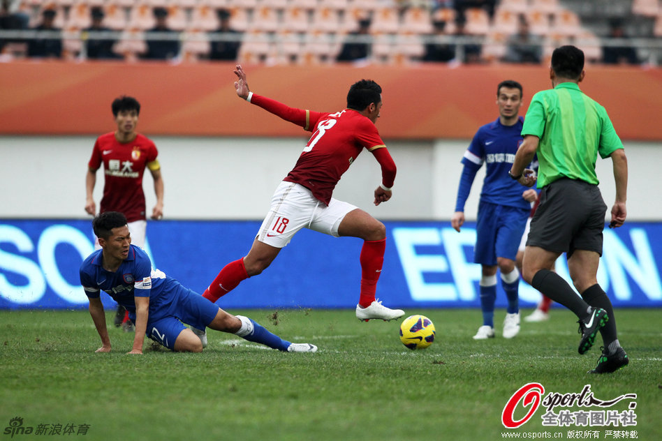 Elkeson of Evergrande dribbles past Wu Xi of Sainty in the Chinese Super Cup in Guangzhou, Guangdong province, on March 3, 2013.