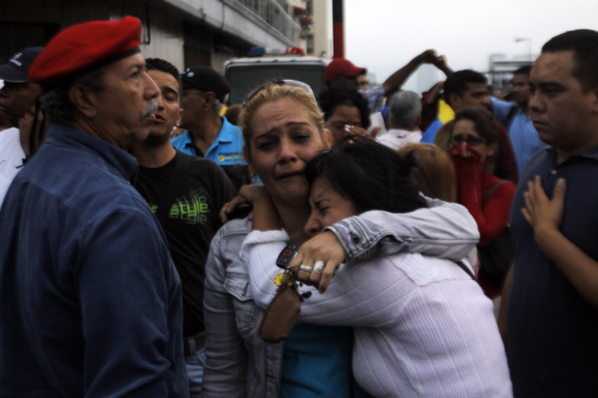 Supporters of Venezuelan President Hugo Chavez cry after knowing of his death in Caracas on March 5, 2013. [Xinhua photo] 