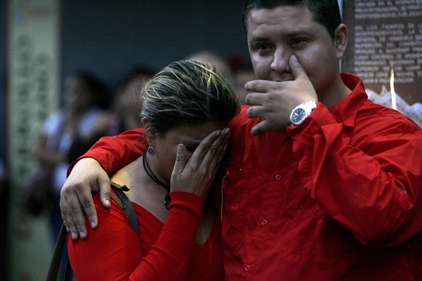 Supporters of Venezuelan President Hugo Chavez cry after knowing of his death in Caracas on March 5, 2013. [Xinhua photo]