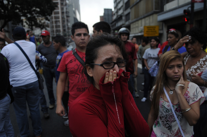 Supporters of Venezuelan President Hugo Chavez cry after knowing of his death in Caracas on March 5, 2013. [Xinhua photo]