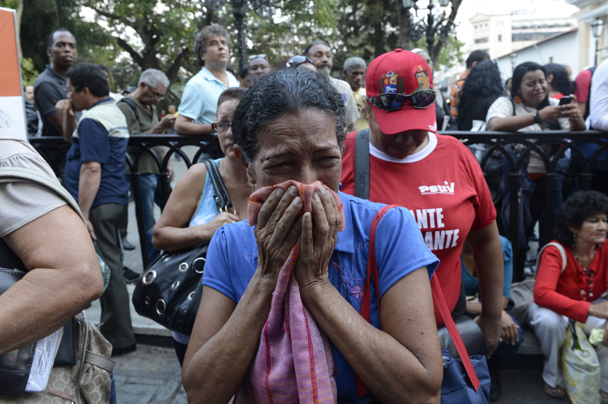 Supporters of Venezuelan President Hugo Chavez cry after knowing of his death in Caracas on March 5, 2013. [Xinhua photo]