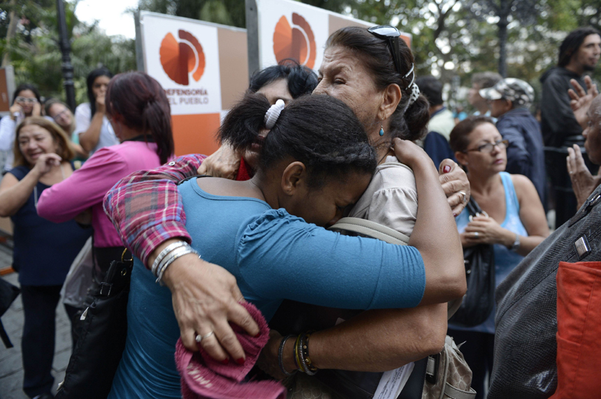 Supporters of Venezuelan President Hugo Chavez cry after knowing of his death in Caracas on March 5, 2013. [Xinhua photo]