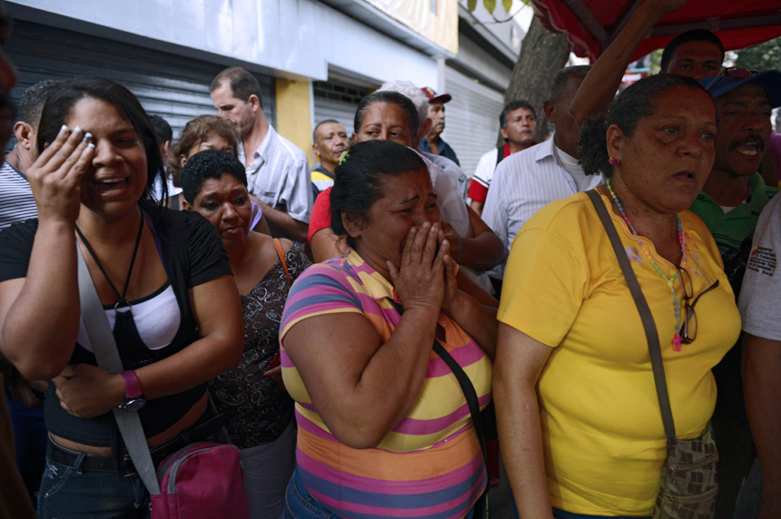 Supporters of Venezuelan President Hugo Chavez cry after knowing of his death in Caracas on March 5, 2013. [Xinhua photo]