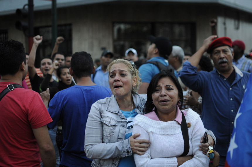 Supporters of Venezuelan President Hugo Chavez cry after knowing of his death in Caracas on March 5, 2013. [Xinhua photo]