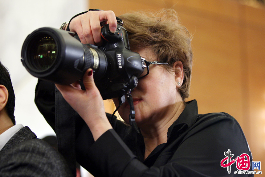 A foreign reporter takes pictures during the press conference of the First Session of the 12th National People’s Congress on March 4, 2013. 