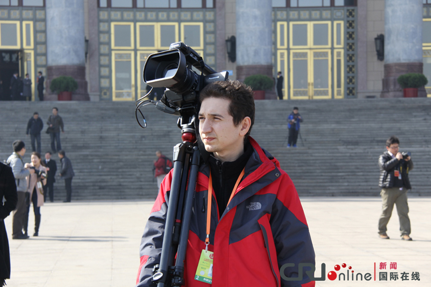 A foreign journalist reports China's political meetings near the Great Hall of the People in Beijing on March 4, 2013. 