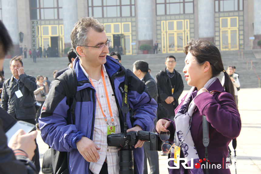 A foreign journalist reports China's political meetings near the Great Hall of the People in Beijing on March 4, 2013. 