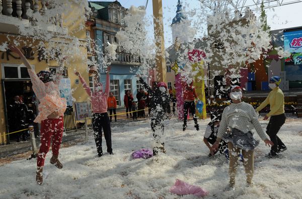 People take part in a pillow fight at a park in Changsha, Hunan province, on March 7, the eve of the International Women's Day. The event was organized as relaxation for the participants, especialy females. [Photo/Asianesphoto]
