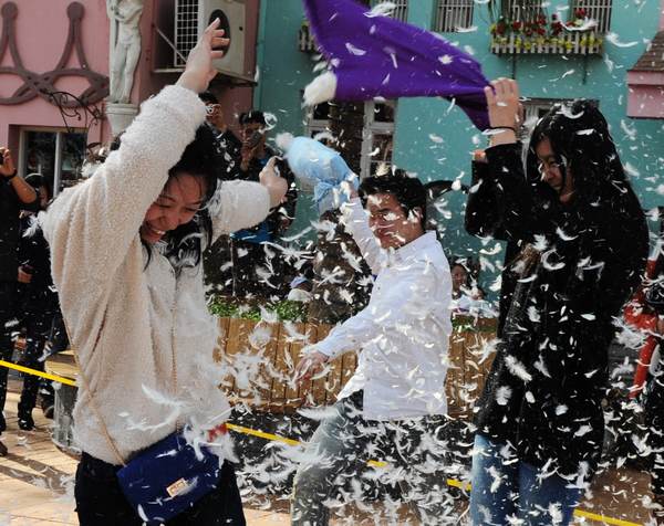 People take part in a pillow fight at a park in Changsha, Hunan province, on March 7, the eve of the International Women's Day. The event was organized as relaxation for the participants, especialy females. [Photo/Asianesphoto]